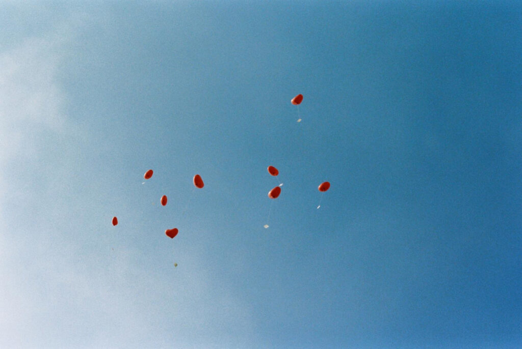 Rote Herz Ballons die am Himmel fliegen.